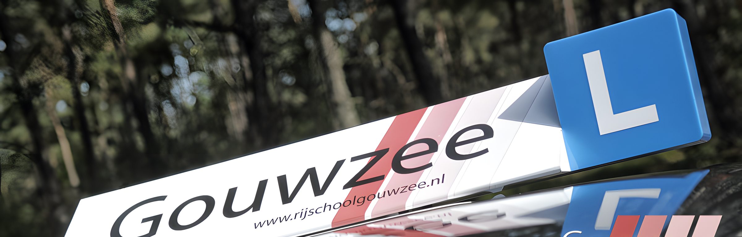 De daklichtbak van Rijschool Gouwzee met het rode strepen-motief en het blauwe L-bord